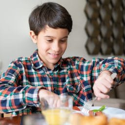 Young boy enjoying a meal at home.