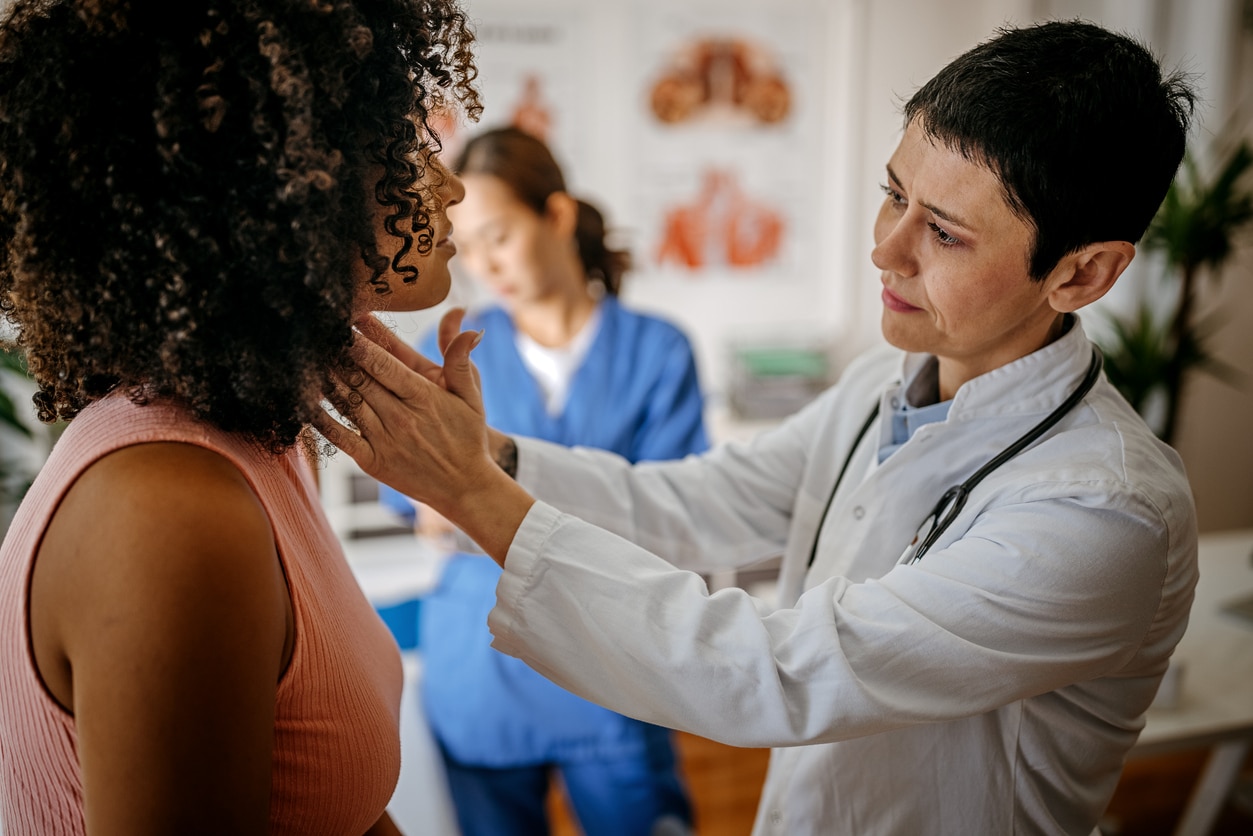 An ENT specialist examining a woman with a sore throat.