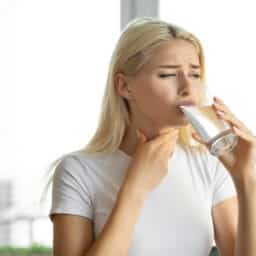 Woman struggling to swallow water.