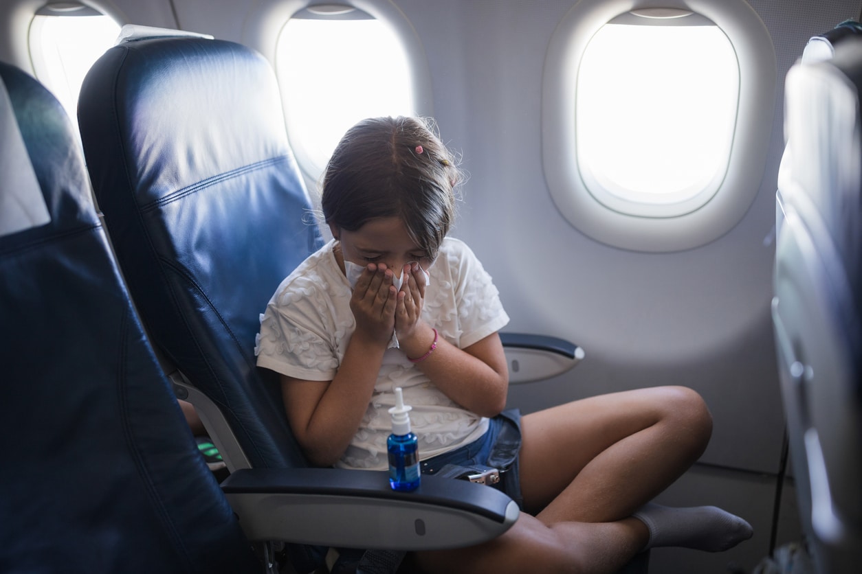 Young girl with a runny nose on a plane.