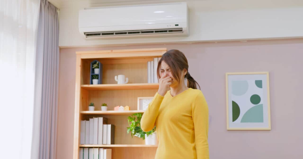 Woman sneezes in a room