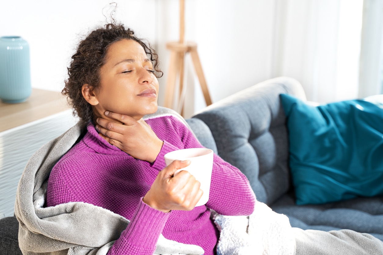 Woman holds neck with sore throat