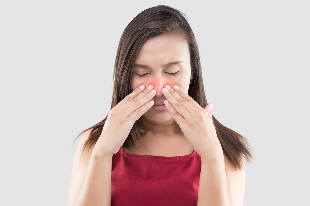 Woman holding her red sinuses.